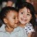 little girl hugs baby boy as they sit on a floor
