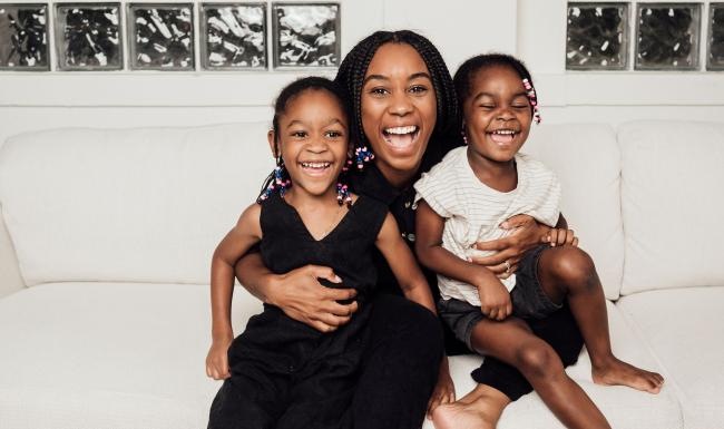 a woman sitting on a couch with two kids